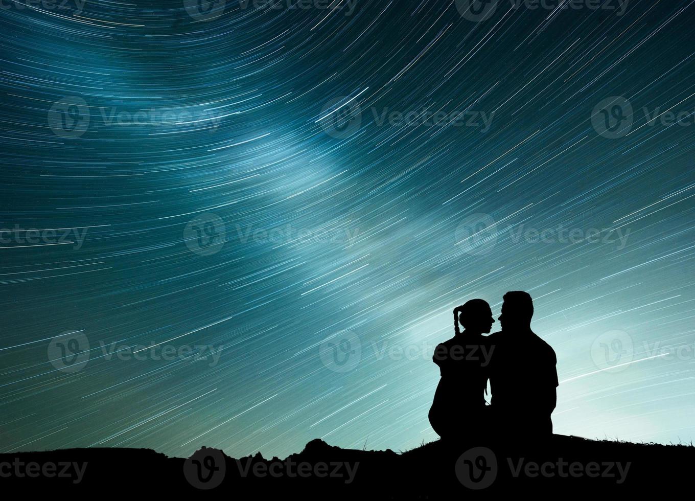 via lattea con silhouette di persone. paesaggio con cielo stellato notturno. uomo e donna in piedi sulla montagna con luce stellare. foto