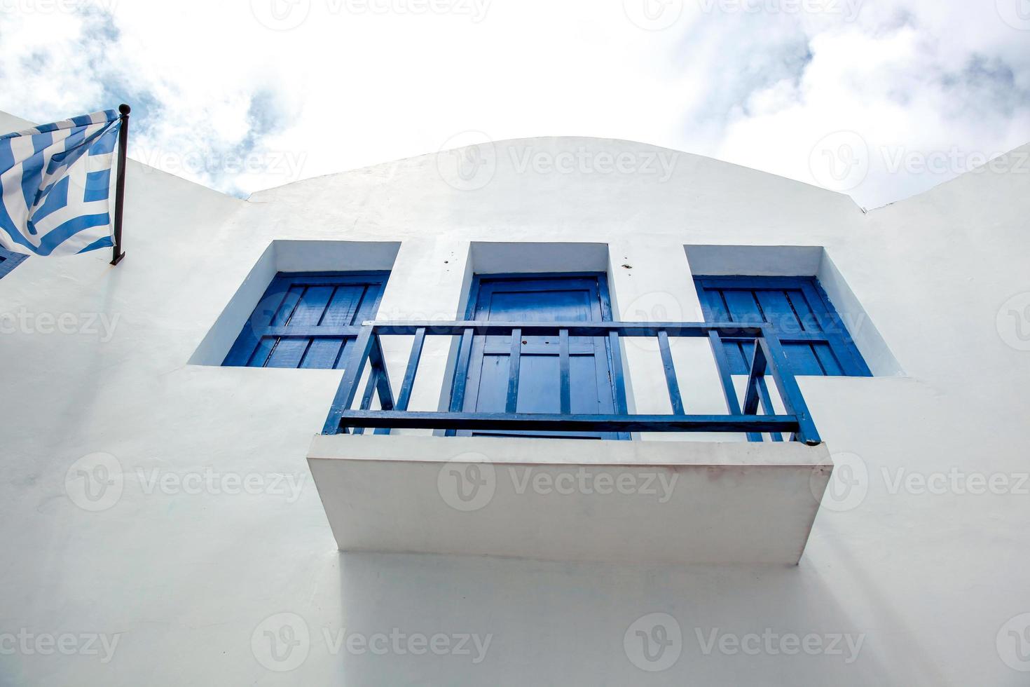 Grecia bianco tradizionale casa balcone con finestre blu e bandiera greca foto