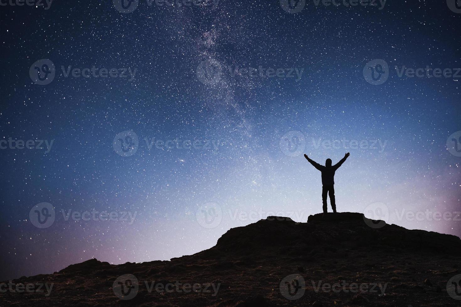 silhouette giovane uomo sfondo della Via Lattea su una stella luminosa tonalità del cielo scuro foto