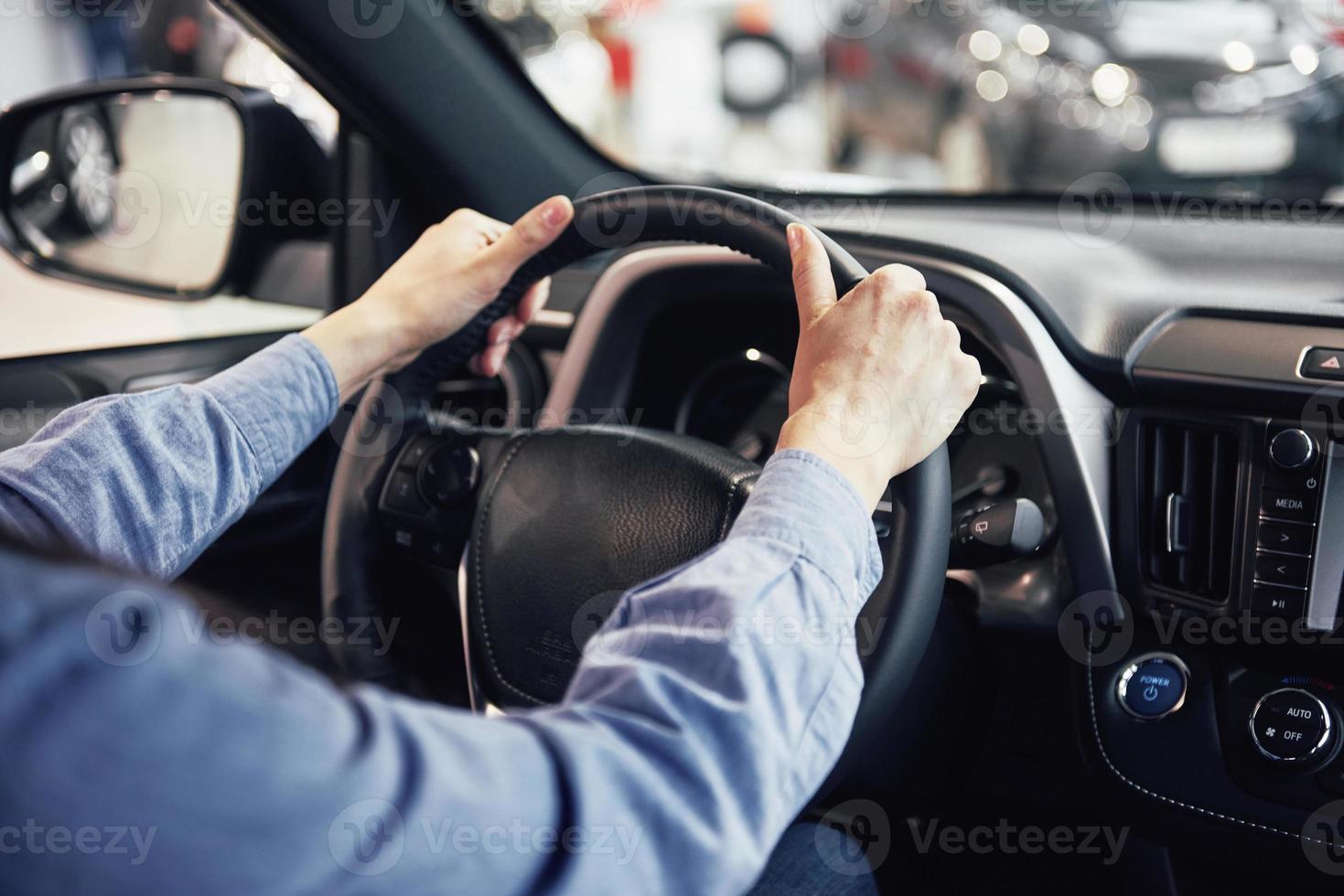 affari automobilistici, vendita di automobili, consumismo e concetto di persone - donna felice che prende la chiave dell'auto dal rivenditore in un salone di auto o in un salone foto