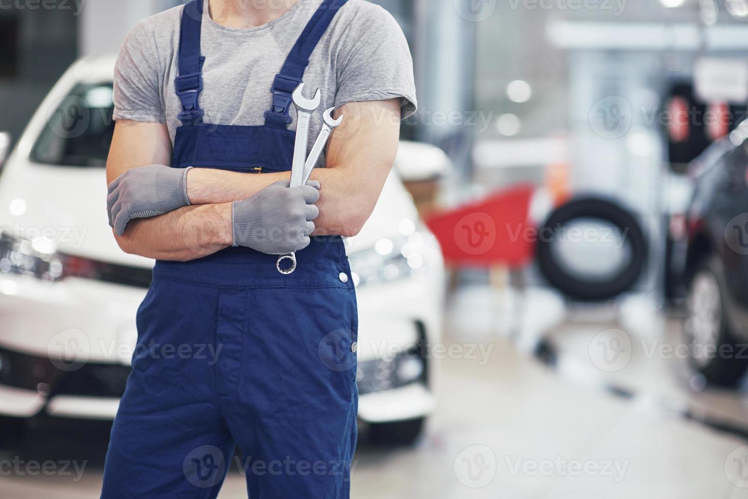 mano del meccanico di automobile con la chiave inglese. officina di riparazione auto foto