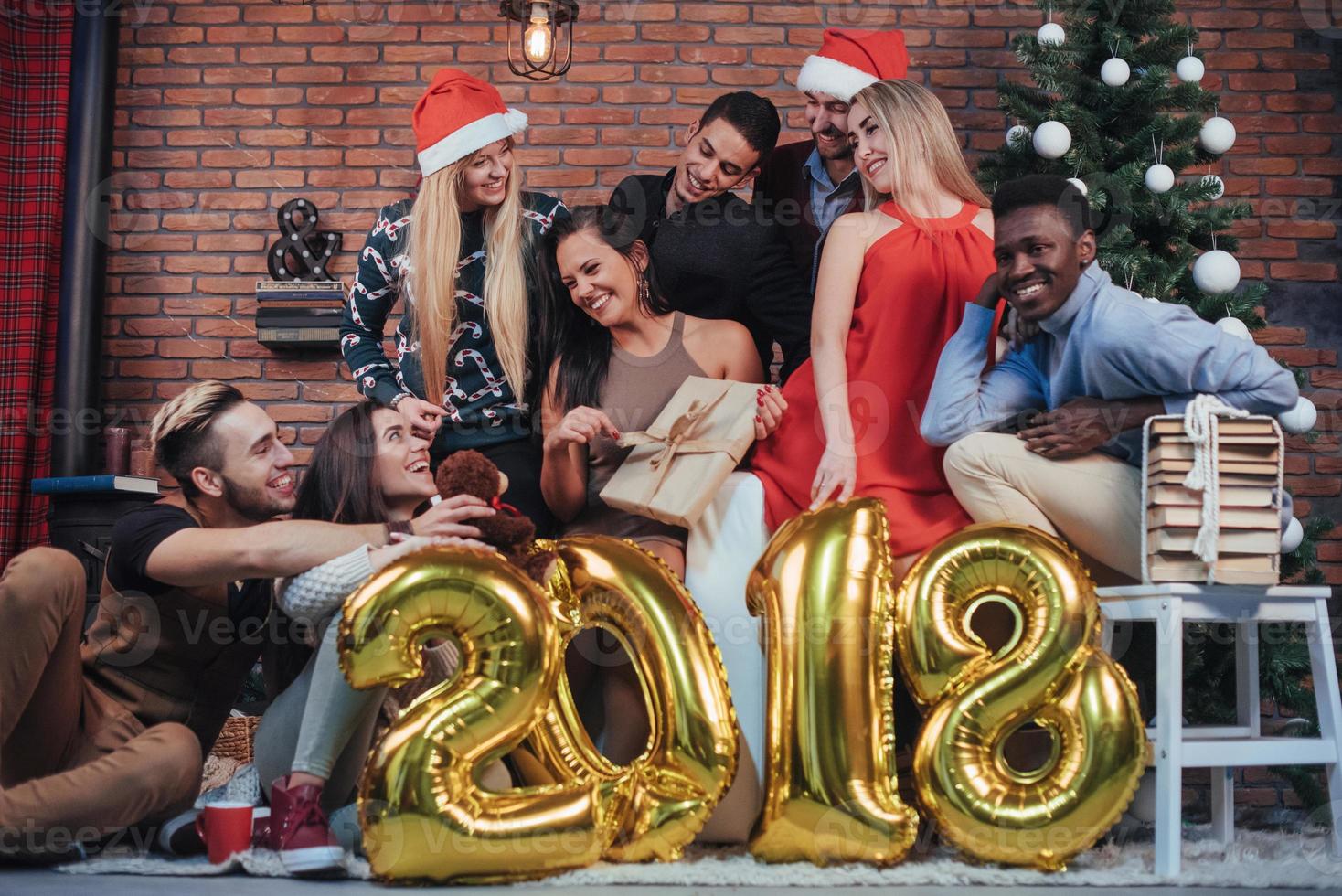 gruppo di vecchi amici allegri comunicano tra loro. il nuovo anno 2018 sta arrivando. festeggia il nuovo anno in un'accogliente atmosfera di casa foto