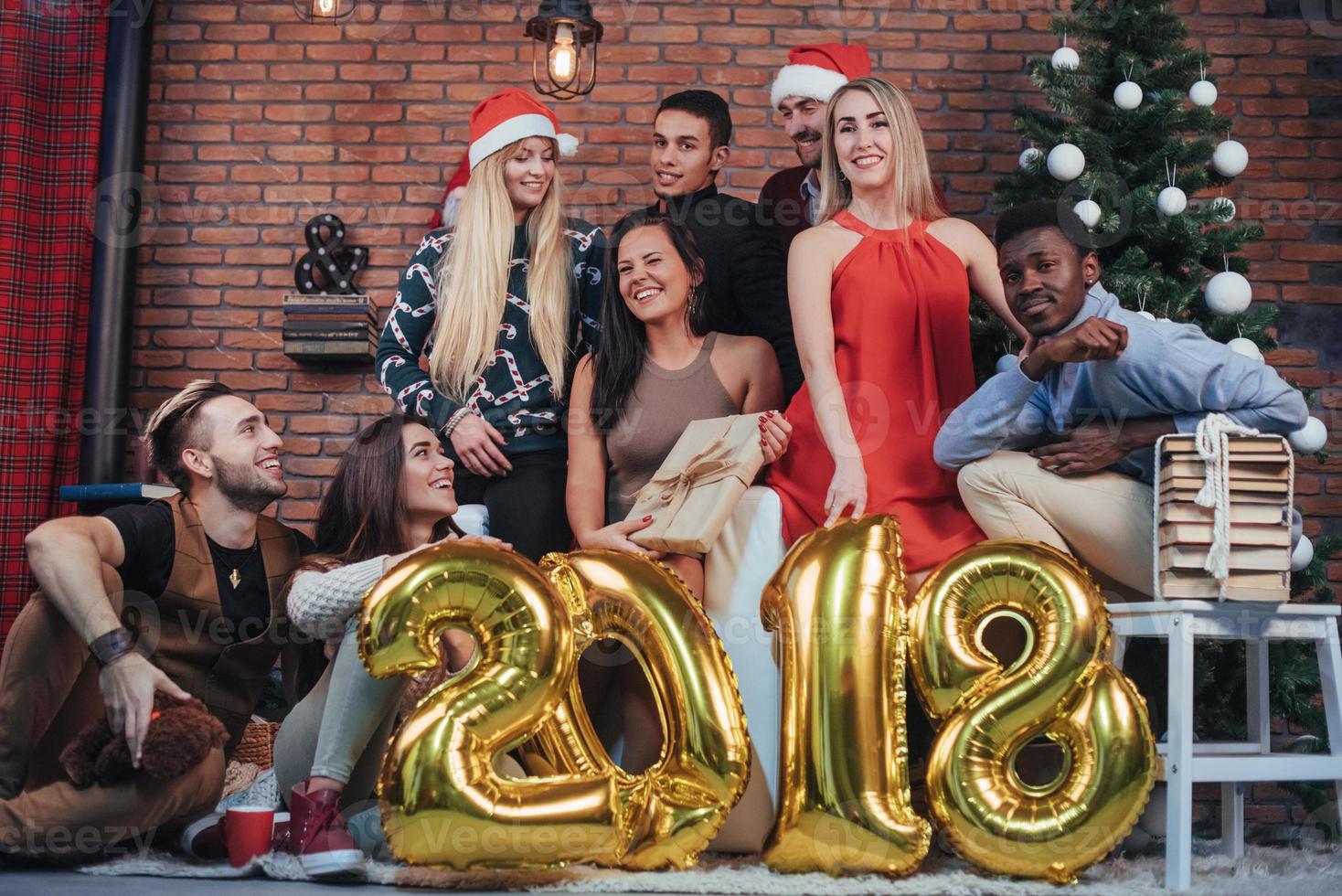 gruppo di vecchi amici allegri comunicano tra loro. il nuovo anno 2018 sta arrivando. festeggia il nuovo anno in un'accogliente atmosfera di casa foto
