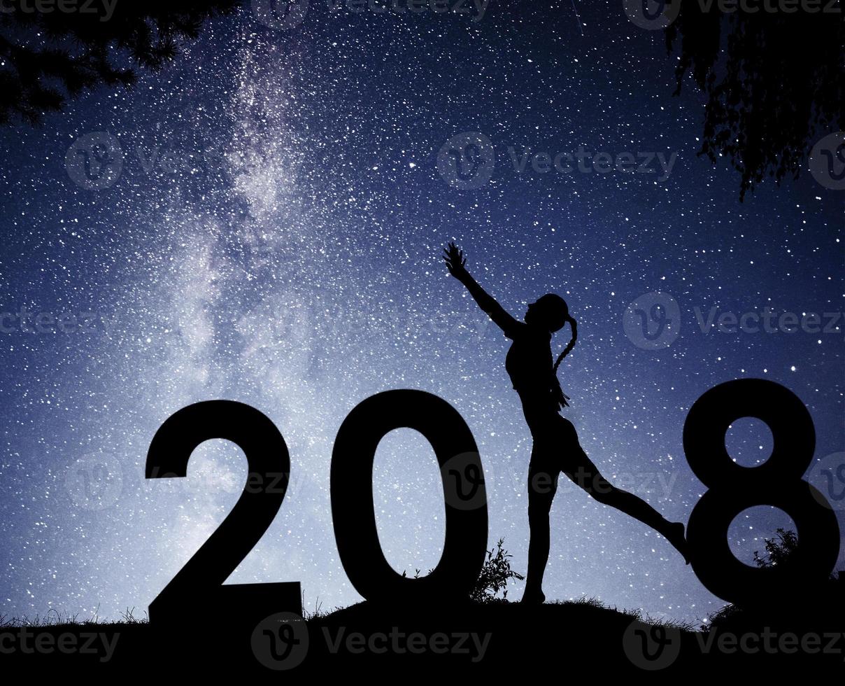 ragazza di sagoma. felice anno nuovo 2018. sfondo della Via Lattea su una stella luminosa tonalità del cielo scuro foto