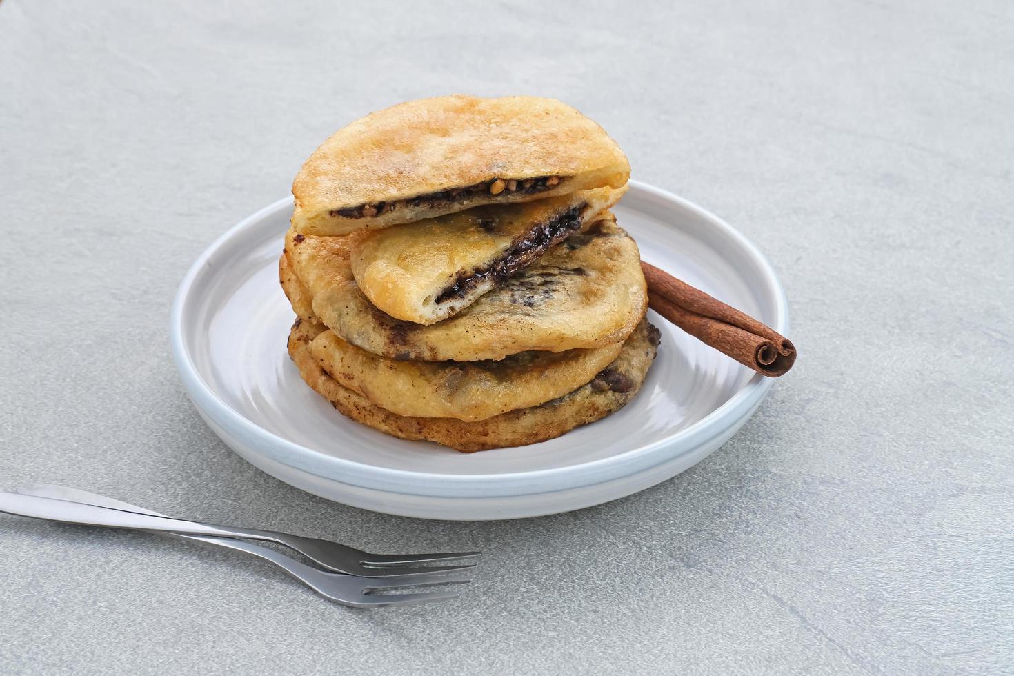 hotteok, frittelle sudcoreane o pasta fritta con ripieno di noci e zucchero, cibo di strada tradizionale. messa a fuoco selezionata. foto