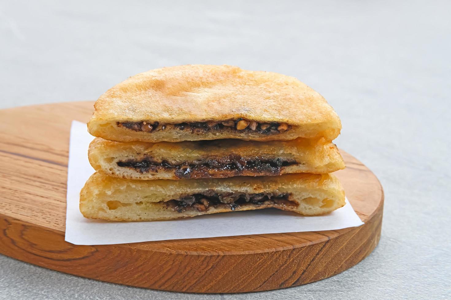 hotteok, frittelle sudcoreane o pasta fritta con ripieno di noci e zucchero, cibo di strada tradizionale. messa a fuoco selezionata. foto