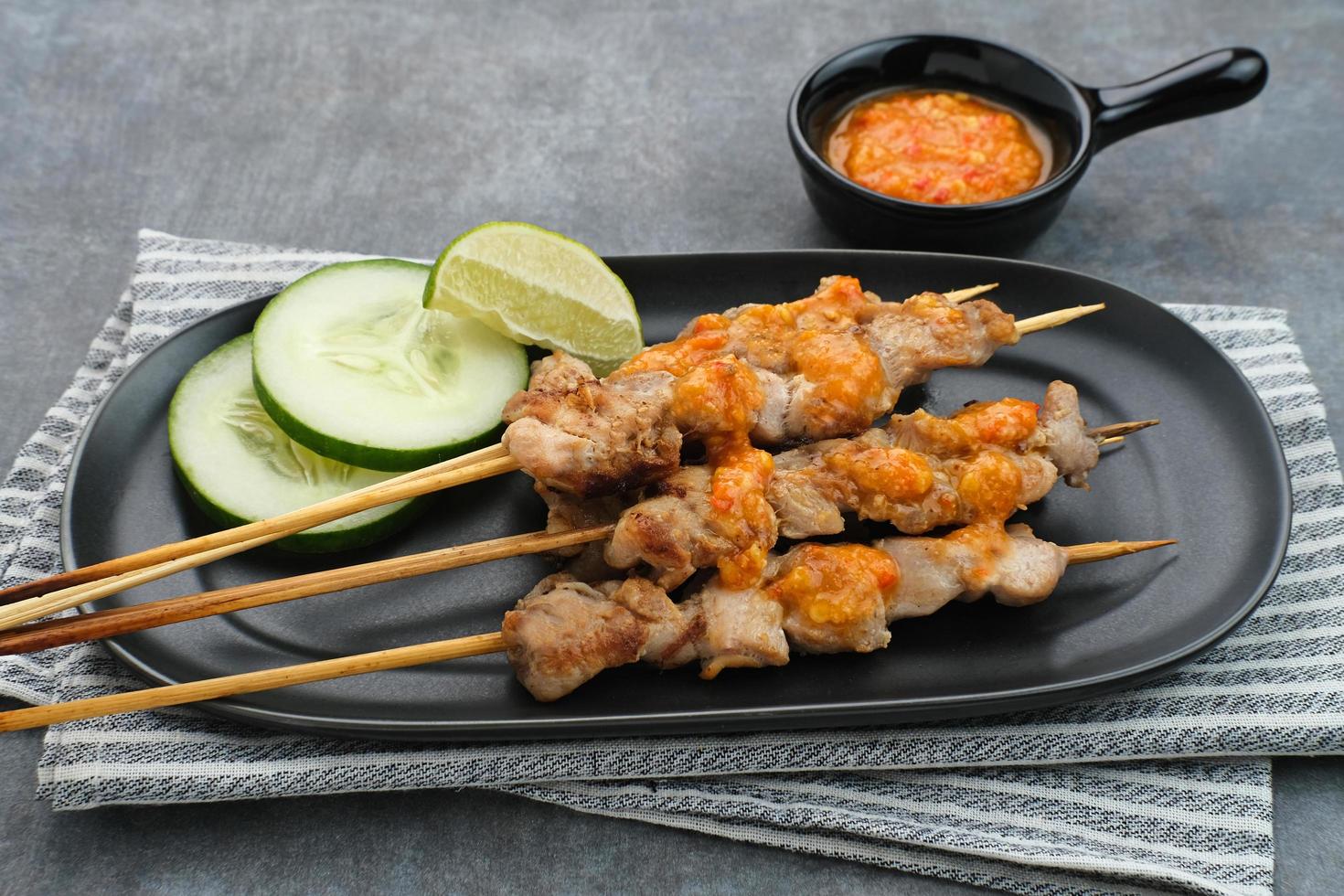 sate taichan, satay di pollo alla griglia senza salsa di arachidi o salsa di soia. servito su piatto con salsa di peperoncino. foto