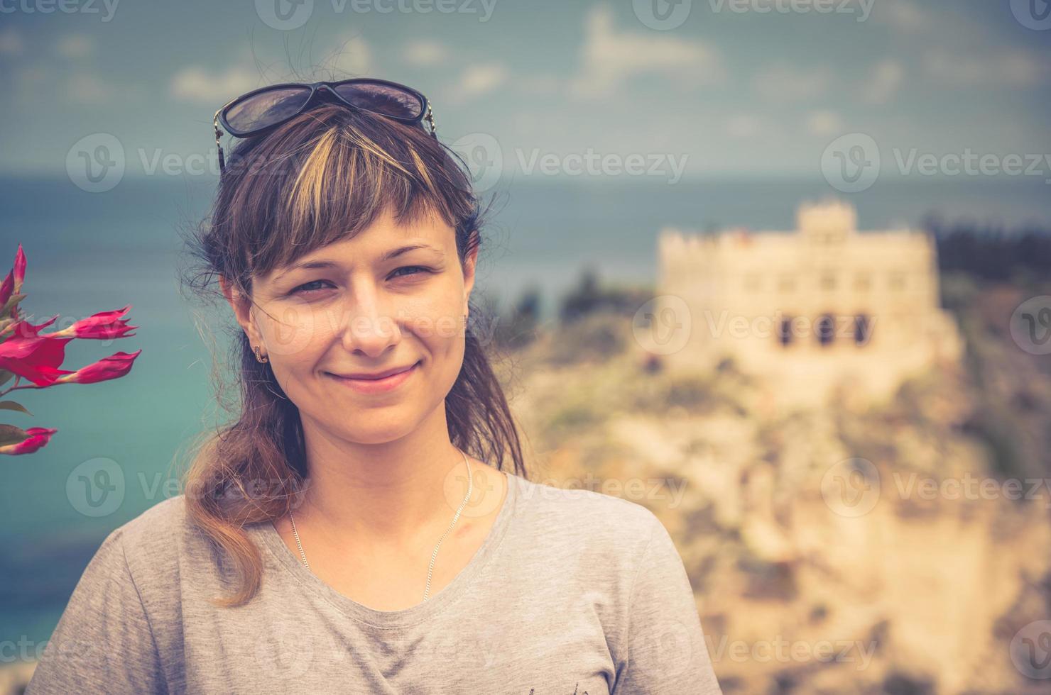 ritratto ravvicinato di una giovane ragazza caucasica viaggiatore con t-shirt grigia e occhiali da sole guardando la fotocamera foto