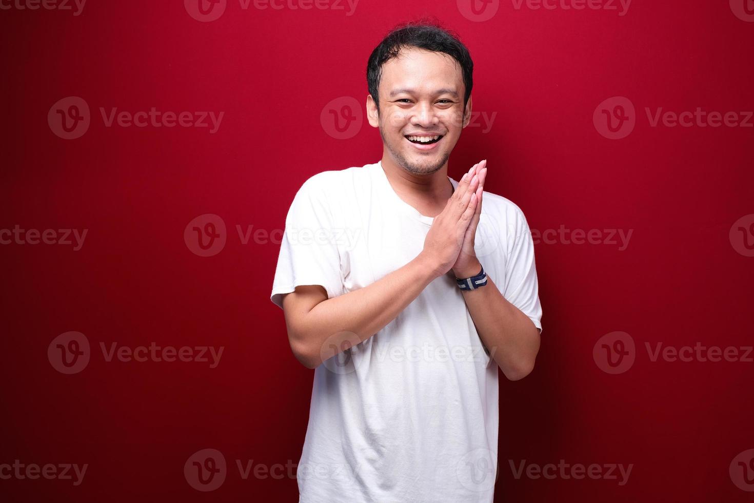 sorriso compiaciuto volto sorridente di giovane uomo asiatico con la mano di saluto foto