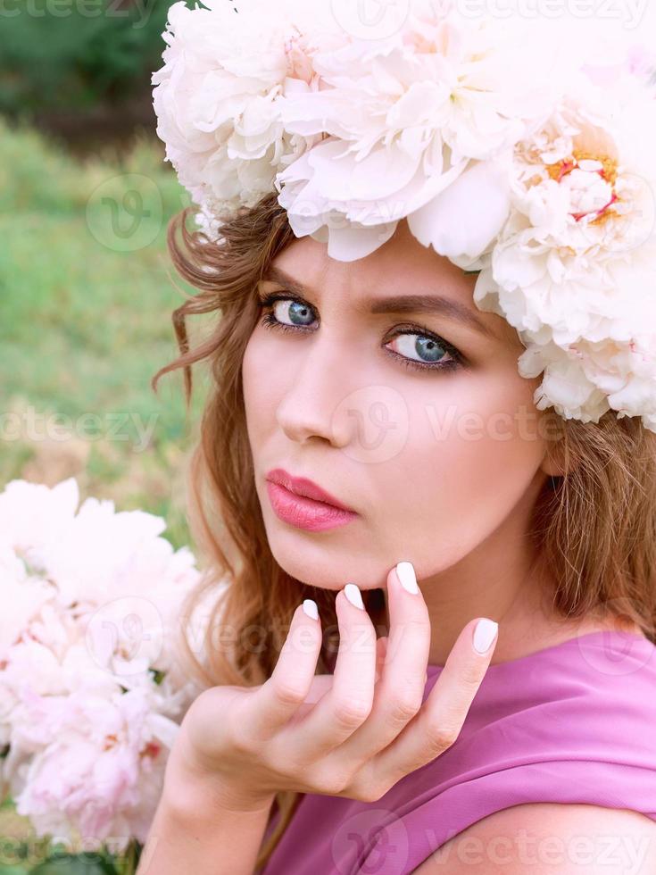 bella donna caucasica con una corona di peonie in testa. concetto di primavera, fiore, fata foto