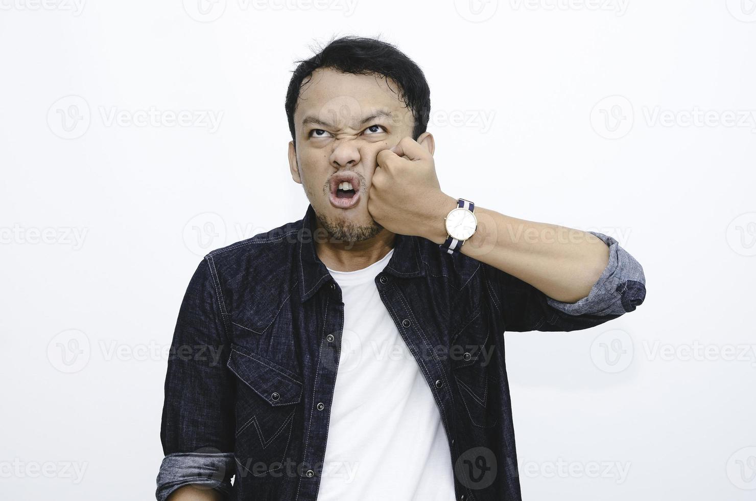 faccia buffa dell'uomo asiatico arrabbiato si punisce colpendolo sulla propria faccia. foto