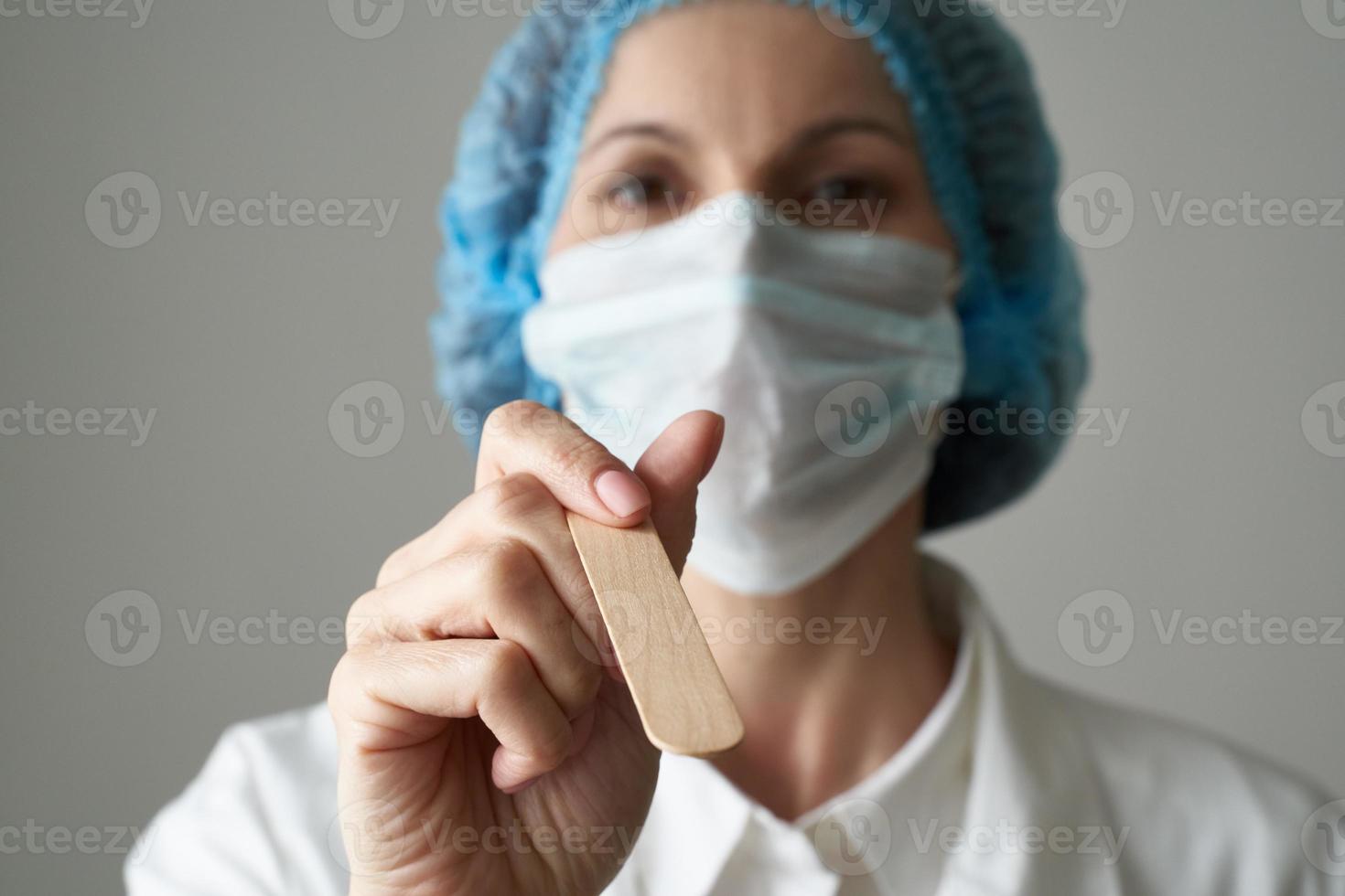 dottoressa in maschera medica e controllo uniforme delle condizioni della gola. protezione dalle malattie, foto