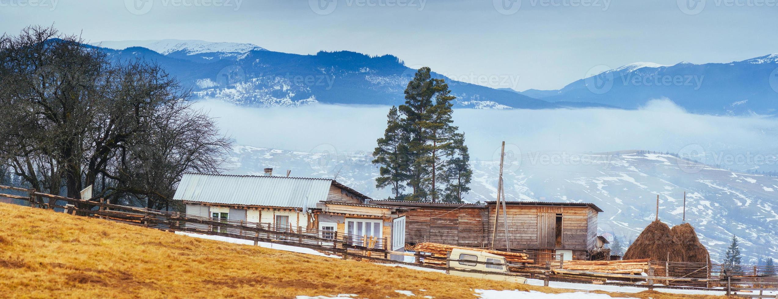 vecchia casa di legno in montagna in un tempo nebbioso foto