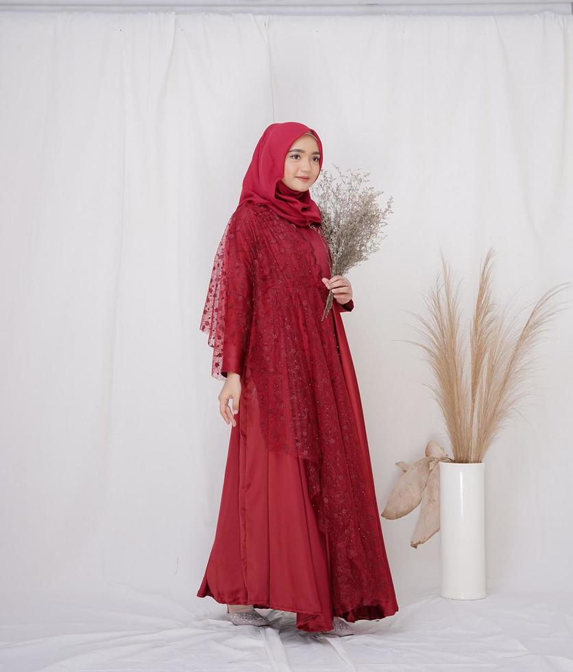 bellissimo modello femminile islamico che indossa la moda hijab, un vestito di stile di vita moderno per donna musulmana. concetto un abito da sposa, bellezza o eidul fitri. una modella asiatica che indossa l'hijab durante un servizio fotografico al coperto foto