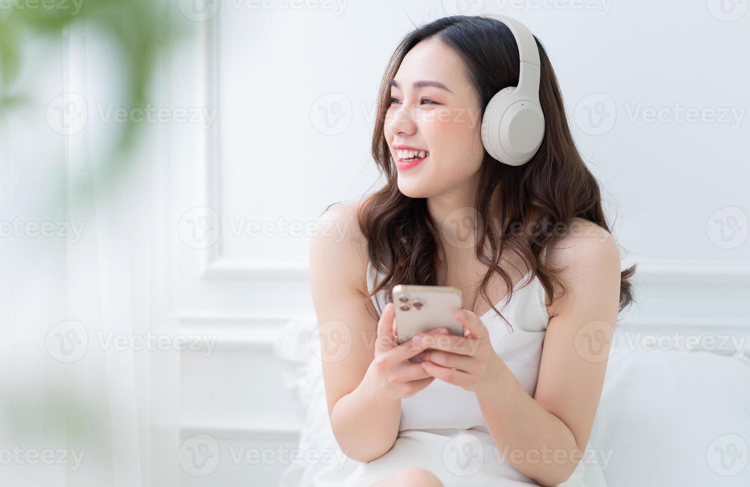 immagine di giovane donna asiatica che ascolta musica a casa al mattino foto