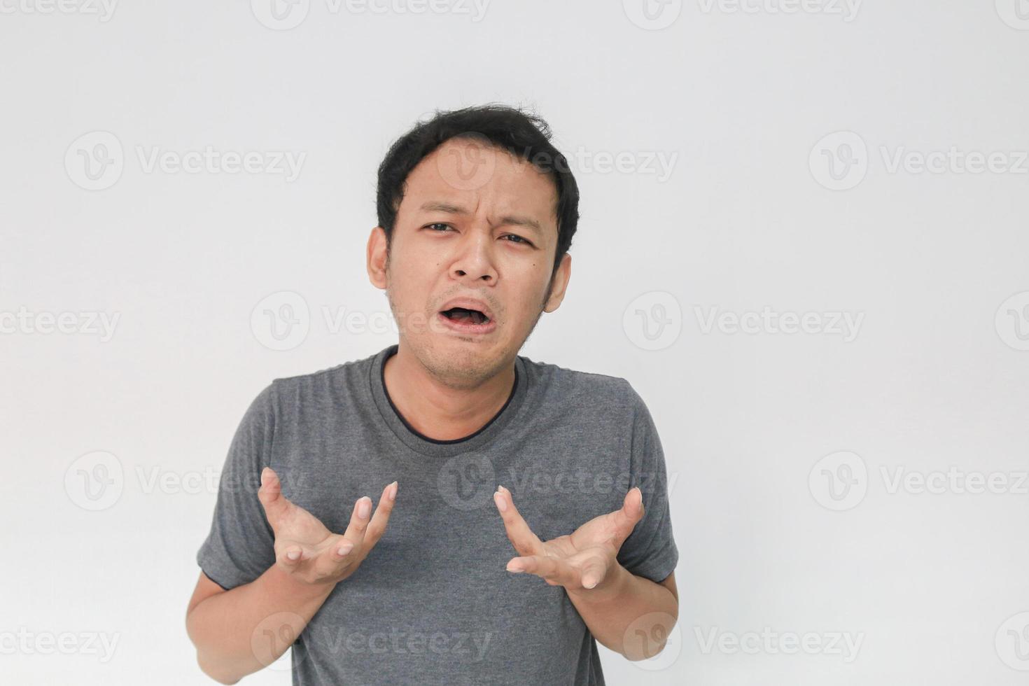 espressione triste e spaventata del giovane asiatico in maglietta grigia foto