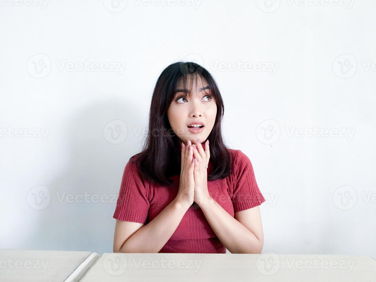 giovane donna asiatica che pensa gesto guardando sopra isolato su sfondo bianco foto