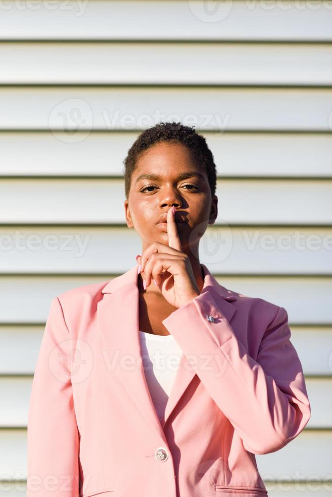 donna d'affari afroamericana che fa gesto di silenzio. foto