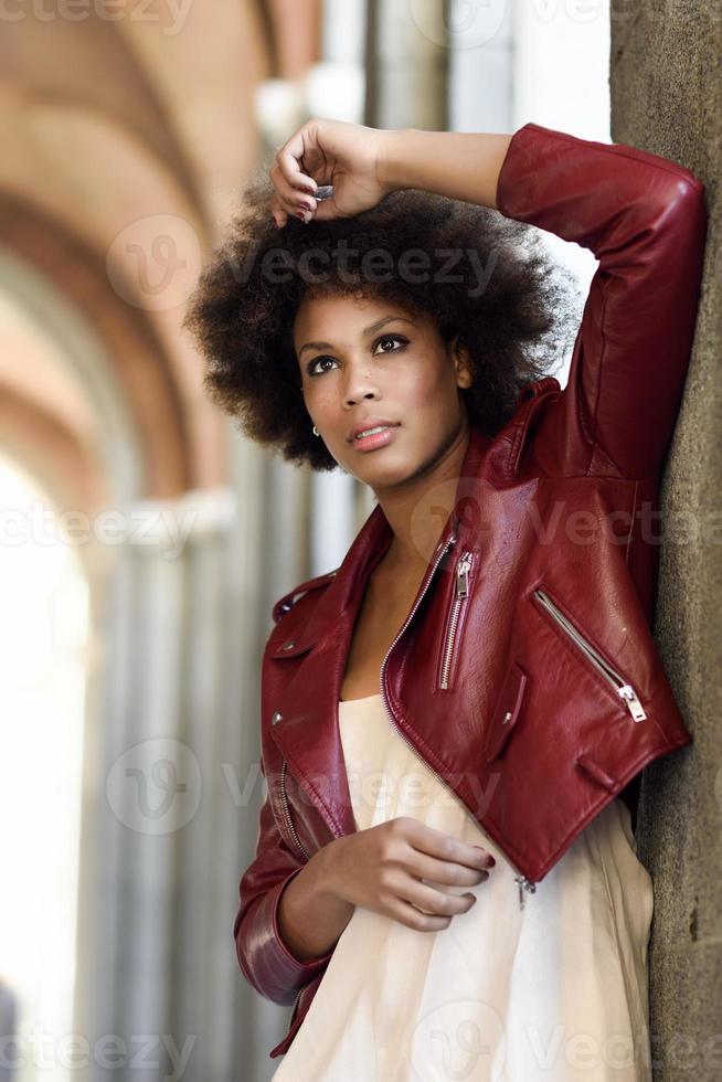 giovane donna nera con acconciatura afro in piedi in fondo urbano foto