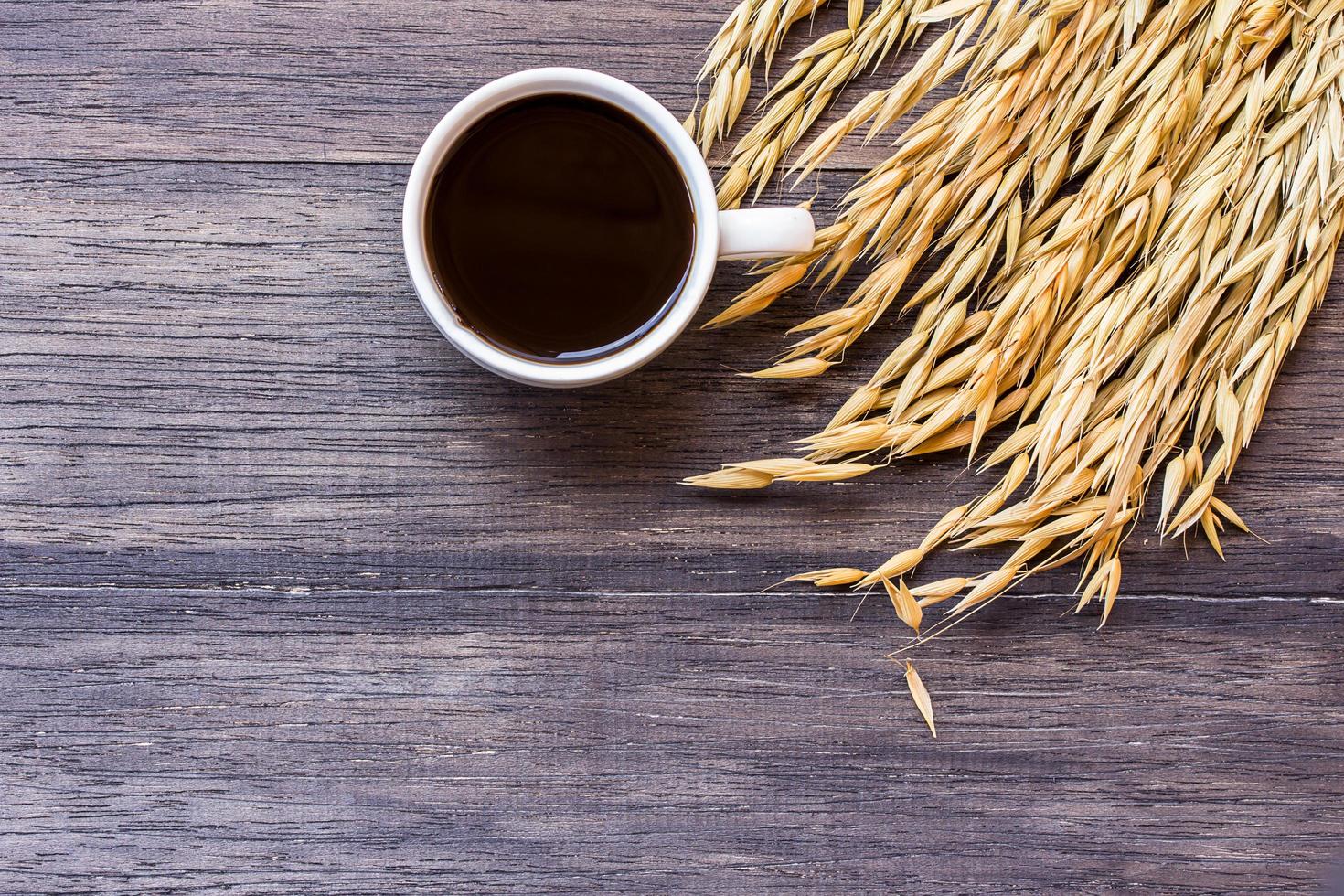 spighe di grano e tazza di caffè sul tavolo di legno foto