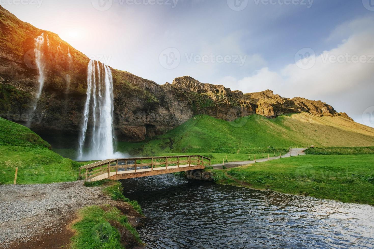 cascata di seljalandfoss al tramonto. ponte sul fiume. fantasie foto