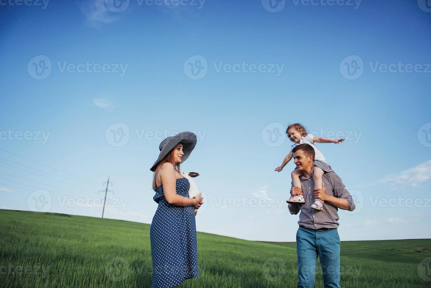 felice famiglia di tre persone che si abbracciano per le strade foto