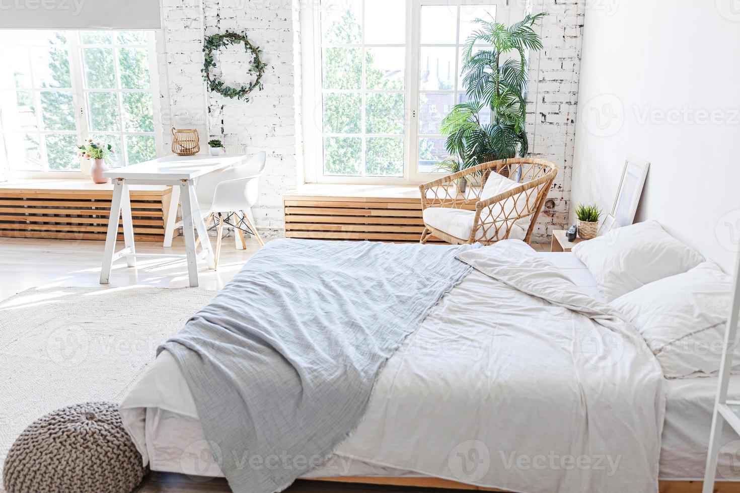 interni eleganti della camera da letto soppalcata. appartamento di design spazioso con pareti chiare grandi finestre letto grande. arredamento moderno e pulito con mobili eleganti in stile scandinavo minimalista. foto