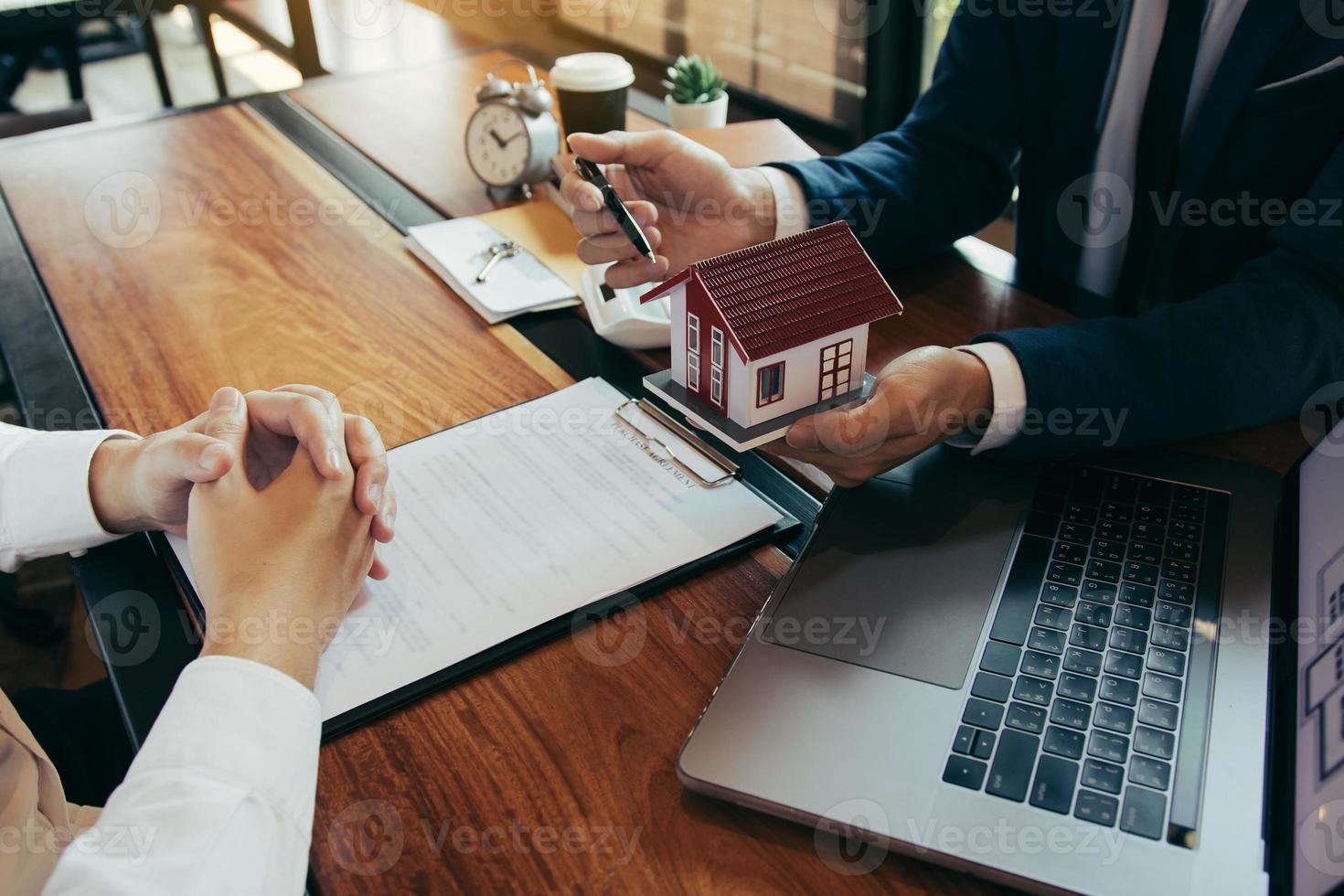 i nuovi acquirenti di case stanno firmando un contratto di acquisto di casa presso la scrivania dell'agente. foto