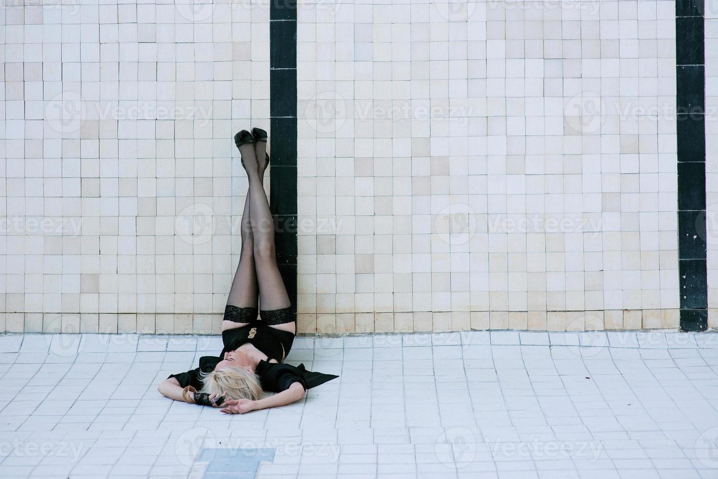 giovane donna in biancheria intima nera e calze da sola nella piscina vuota foto