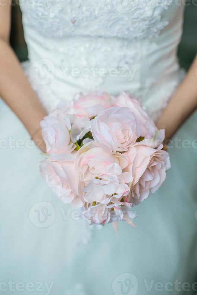 primo piano delle mani di una sposa in possesso di un bouquet da sposa di fiori foto