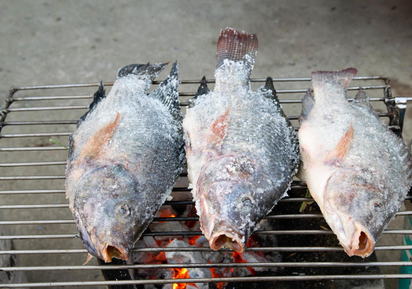 grigliare il pesce sul fuoco foto