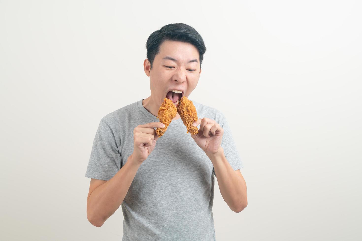 giovane uomo asiatico con pollo fritto a portata di mano foto