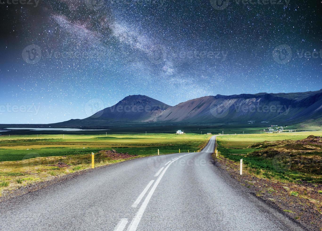 cielo stellato sopra le montagne. la strada asfaltata foto