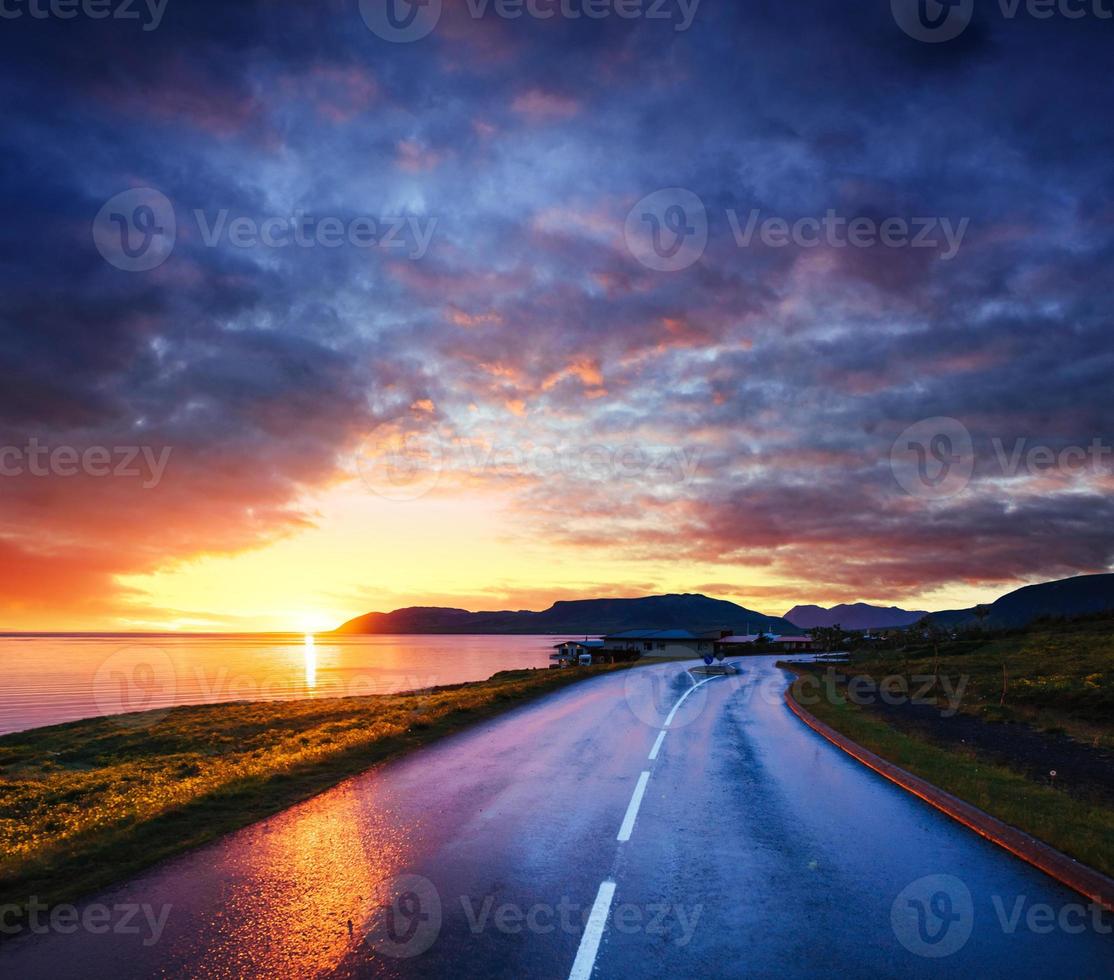 strada asfaltata lungo il mare al tramonto islanda foto