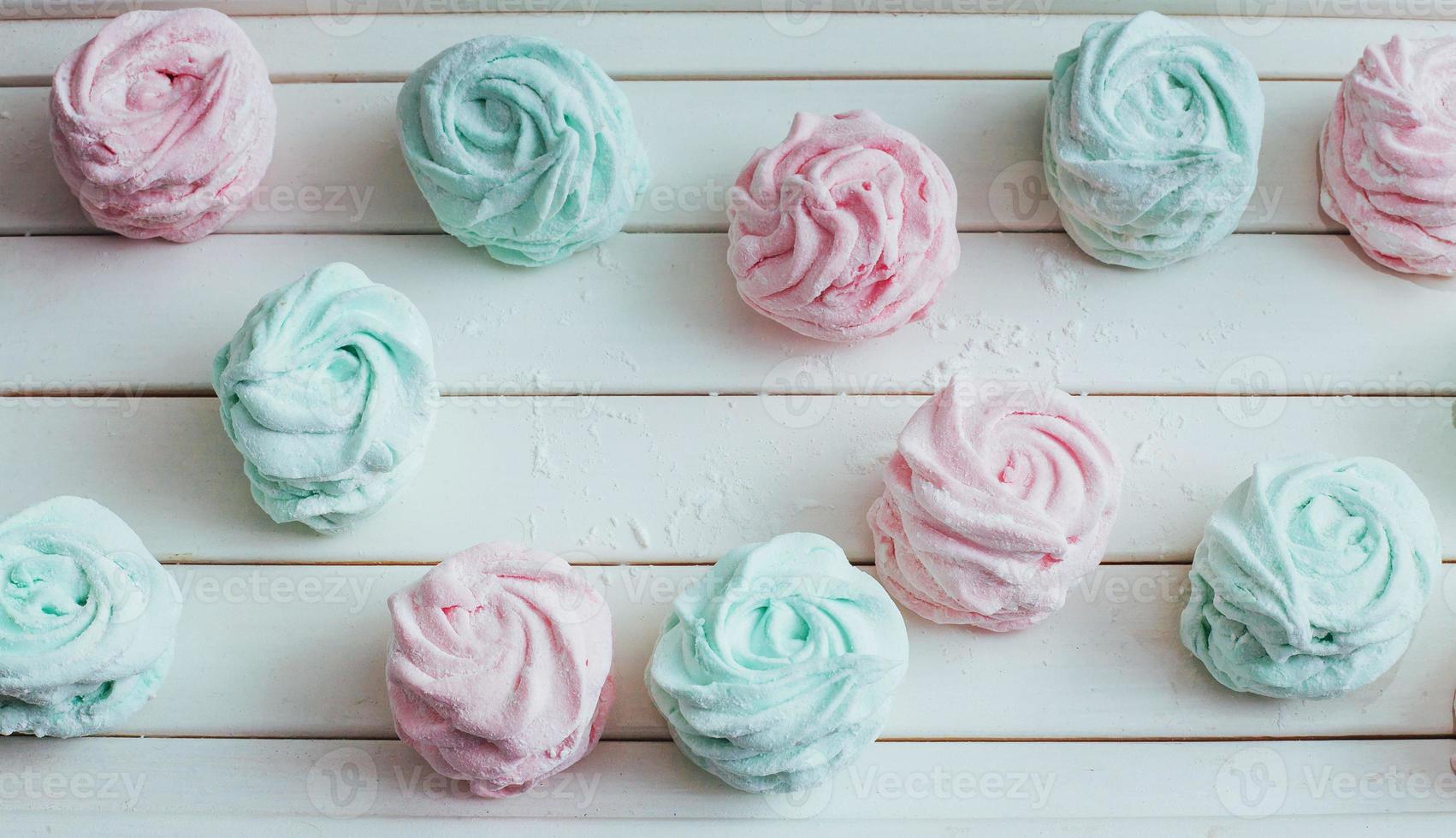 deliziosi marshmallow fatti in casa di diversi colori su una superficie di legno bianca. foto