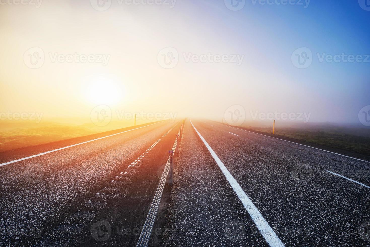 strada in montagna. fitta nebbia al tramonto. Islanda foto