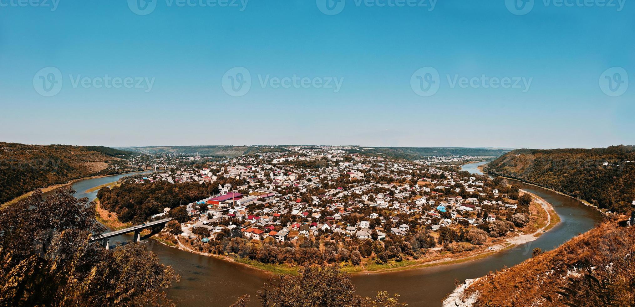 vista panoramica della piccola città penisola rotonda con fiume e ponte in autunno. zalischyky, ucraina europa foto