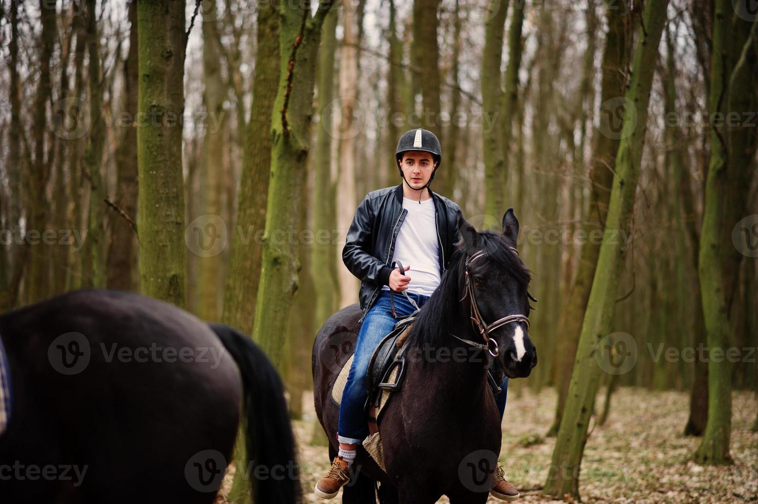 giovane uomo alla moda a cavallo nella foresta d'autunno. foto