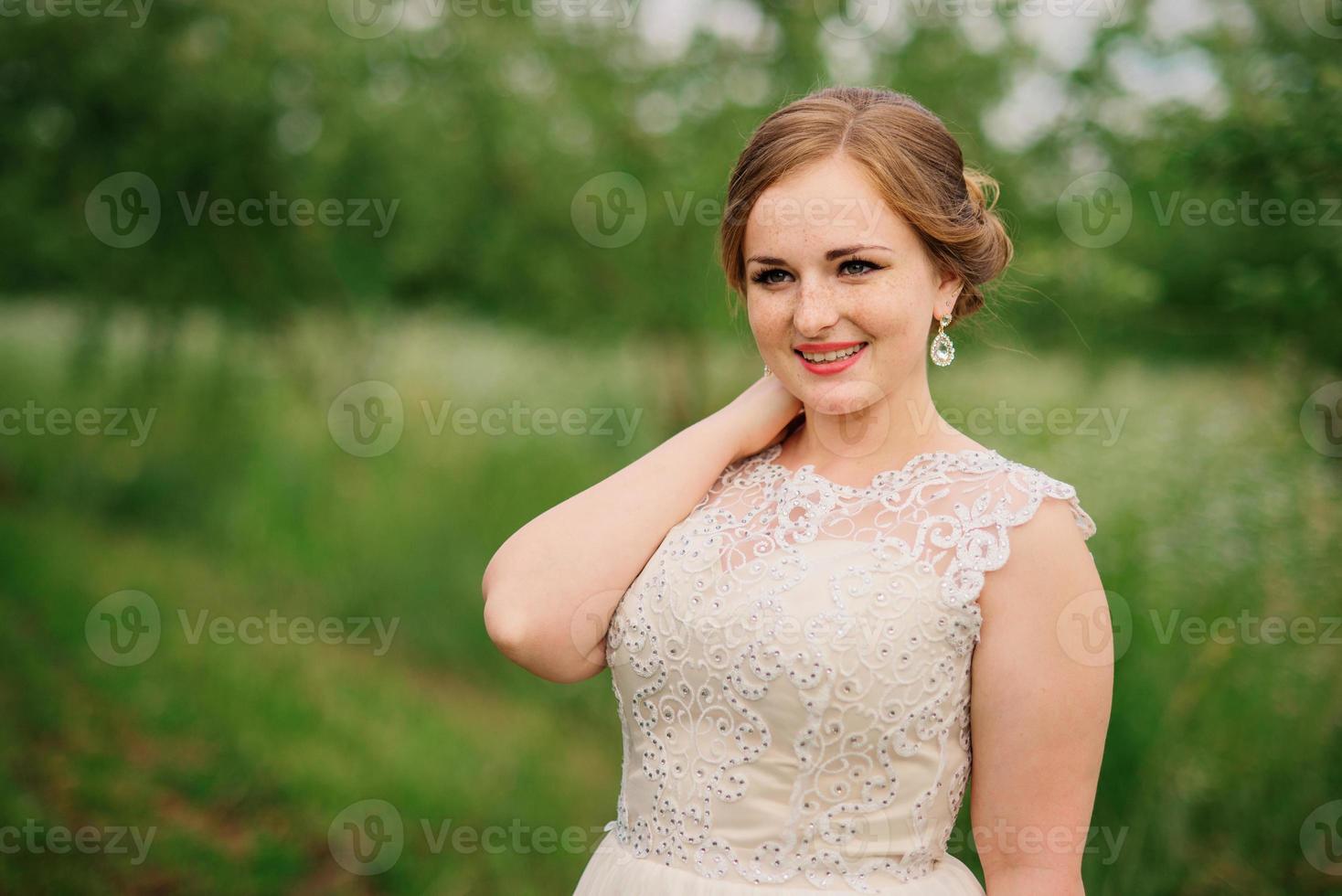 giovane ragazza in sovrappeso in abito beige poste sfondo giardino primaverile. foto