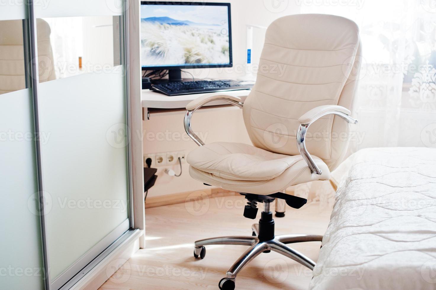 monitor di sfondo della sedia da ufficio di lusso in pelle bianca del computer nella stanza luminosa. foto