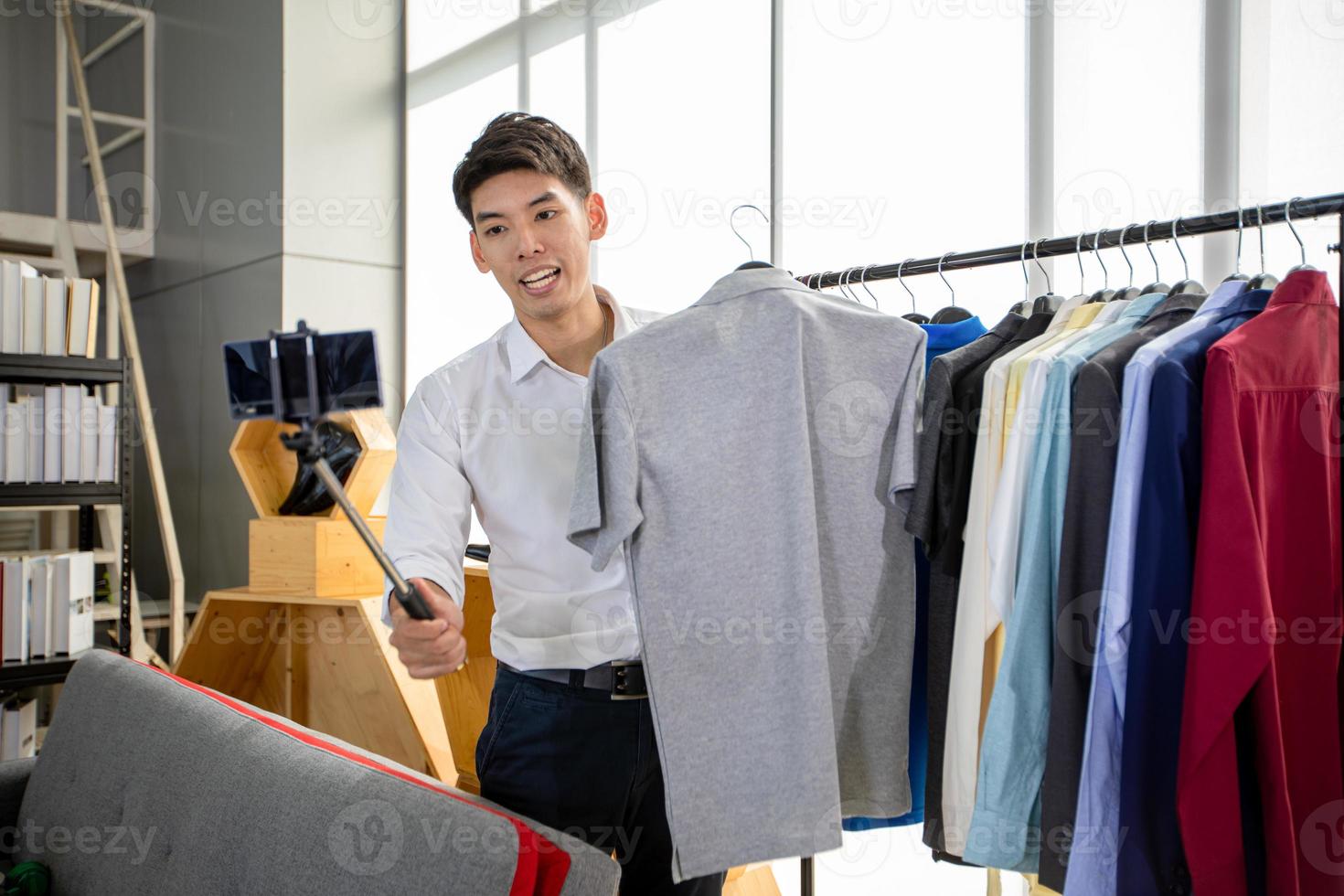 blogger uomo asiatico che trasmette un video per la vendita di prodotti online. Concetto di shopping online foto