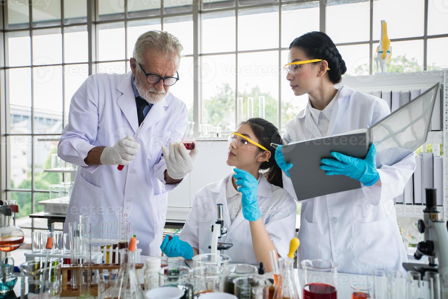 la ricerca medica e gli scienziati stanno lavorando con un microscopio e un tablet e provette, micropipette e risultati di analisi in un laboratorio. foto