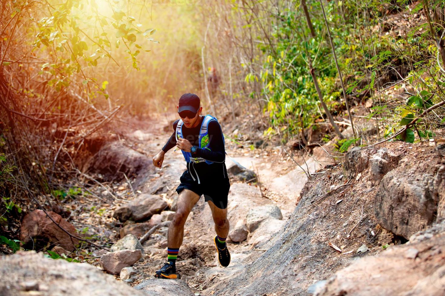 un corridore uomo di trail e piedi d'atleta che indossa scarpe sportive per il trail running nella foresta foto
