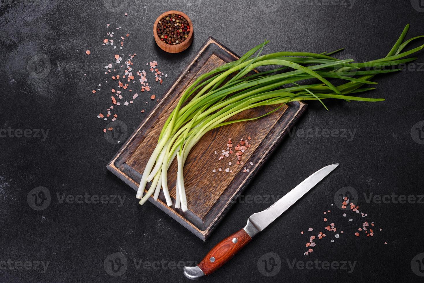 cipolla verde o scalogno su tavola di legno, erba cipollina fresca di primavera foto