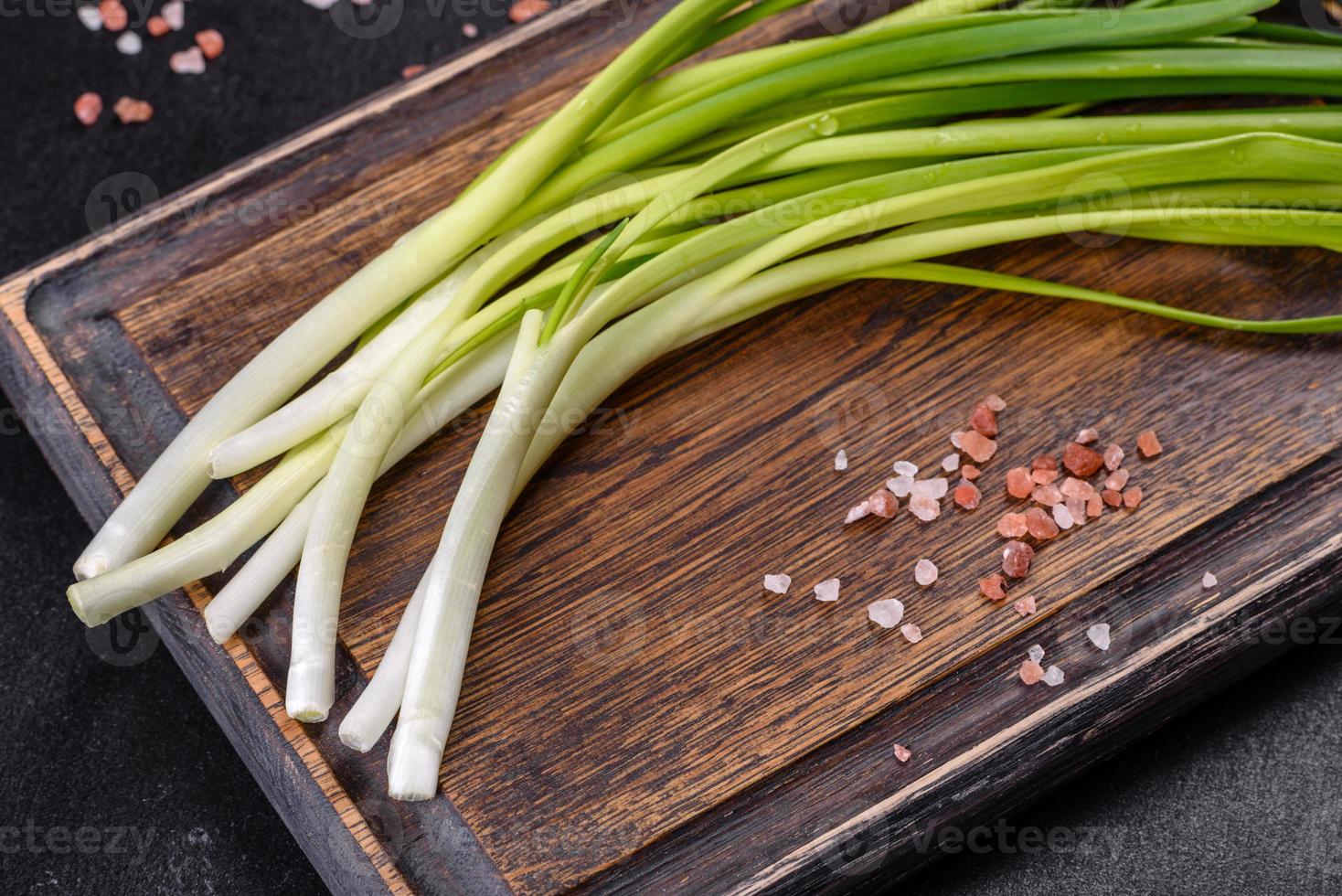 cipolla verde o scalogno su tavola di legno, erba cipollina fresca di primavera foto