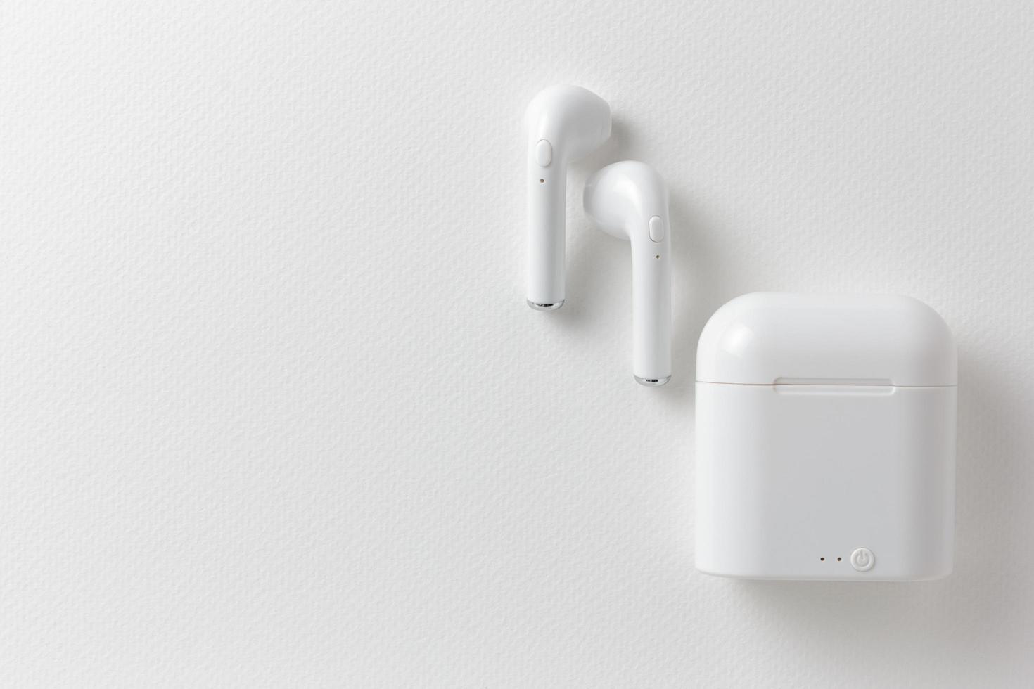 moderni auricolari wireless e custodia di ricarica su sfondo bianco, flat lay.jpg foto