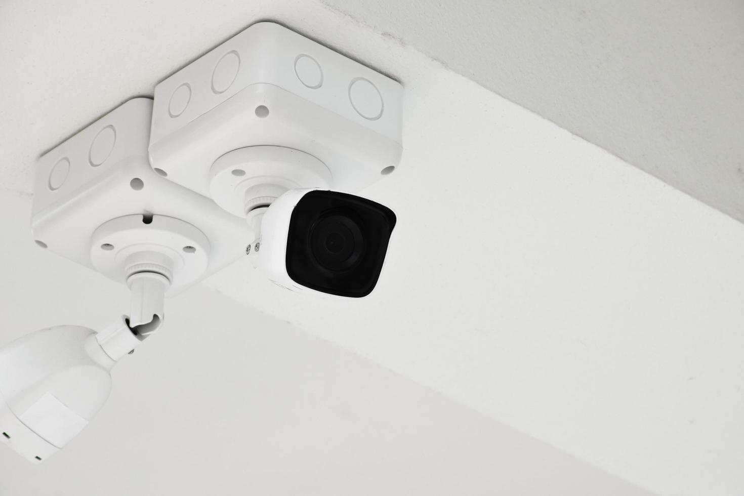 mini telecamera ip cctv installata su un palo di metallo all'esterno della casa, sfondo blu cielo, concetto per l'utilizzo della tecnologia per salvare la vita, la sicurezza e la proprietà. messa a fuoco morbida e selettiva. foto