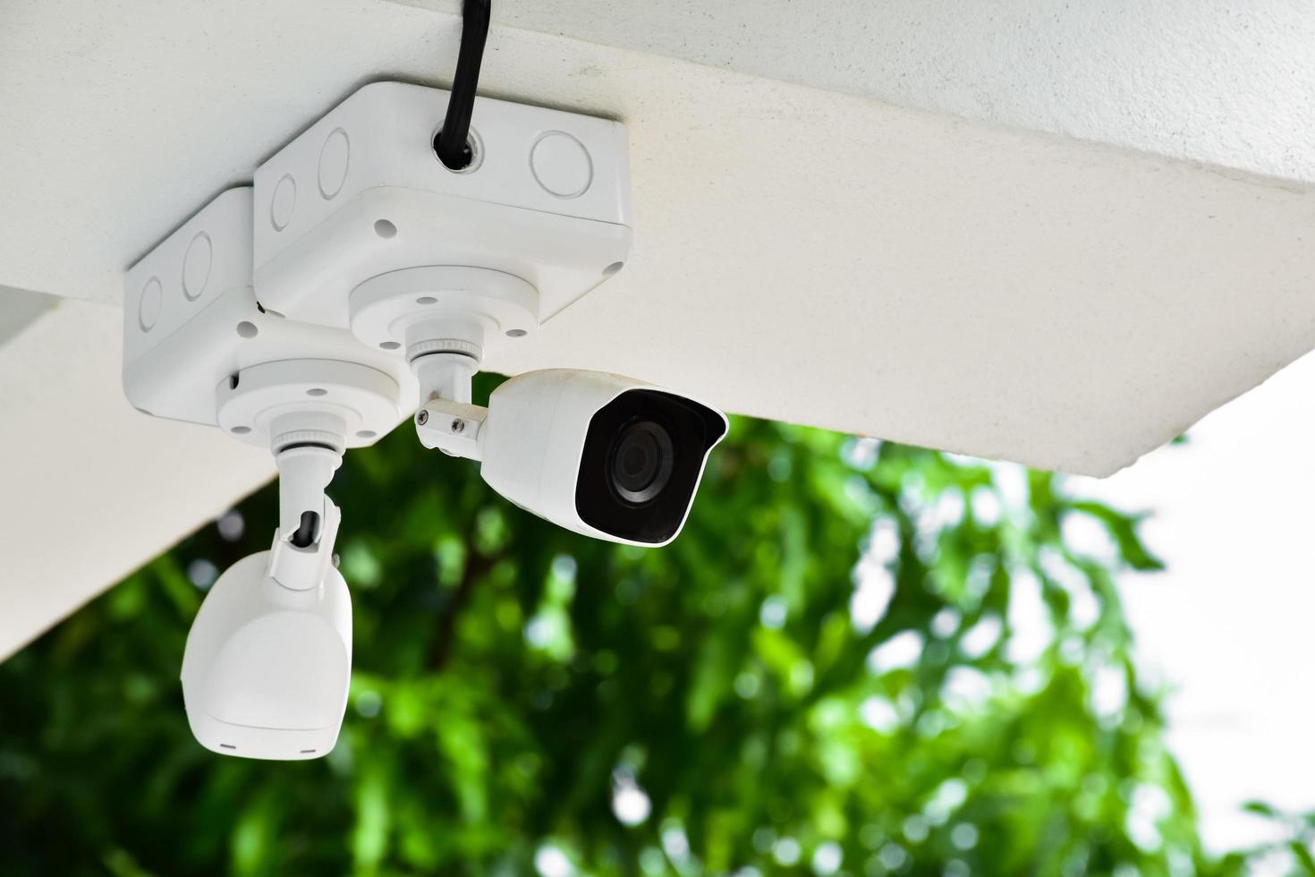 mini telecamera ip cctv installata su un palo di metallo all'esterno della casa, sfondo blu cielo, concetto per l'utilizzo della tecnologia per salvare la vita, la sicurezza e la proprietà. messa a fuoco morbida e selettiva. foto