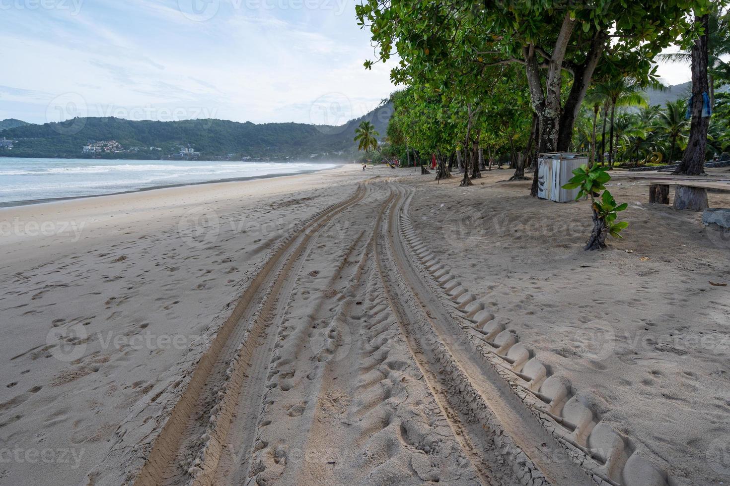 Tracce di pneumatici 4x4 che si incrociano tracce di pneumatici sullo sfondo di texture di sabbia alla spiaggia di patong phuket thailandia foto