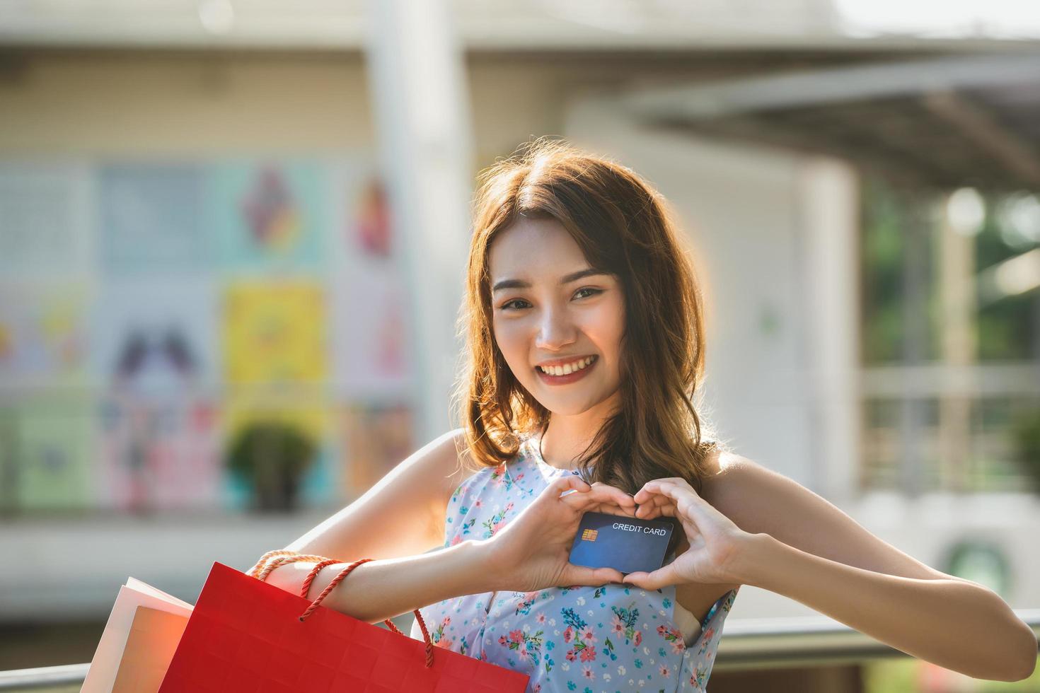 acquisto asiatico della giovane donna paga con la carta di credito. foto